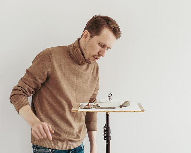 Photo in colour of photographer christian svinddal arranging a still life composition